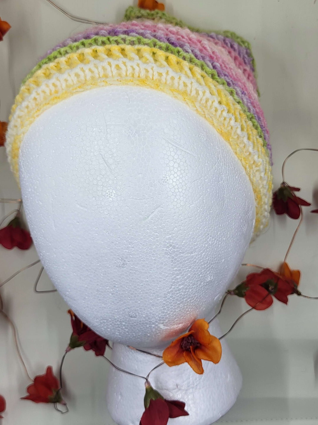 Knit Bandana displayed on a mannequin head with colorful floral accents, showcasing its stylish design.