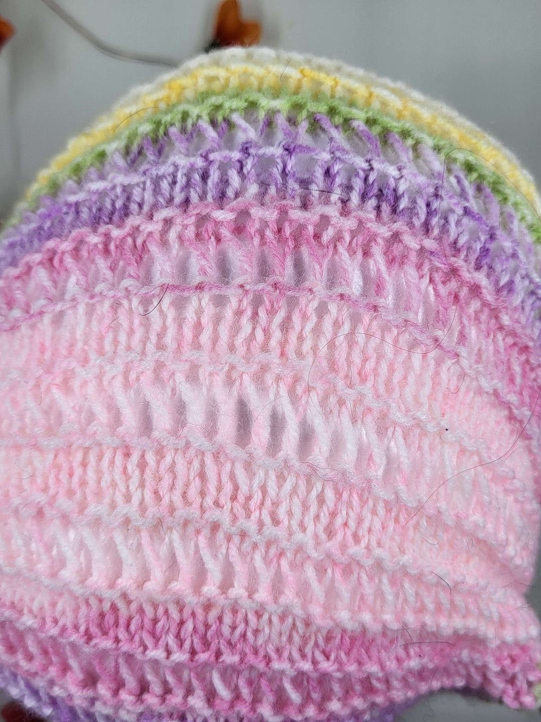 Colorful knit bandana featuring pastel hues of pink, purple, and green, perfect for any occasion.