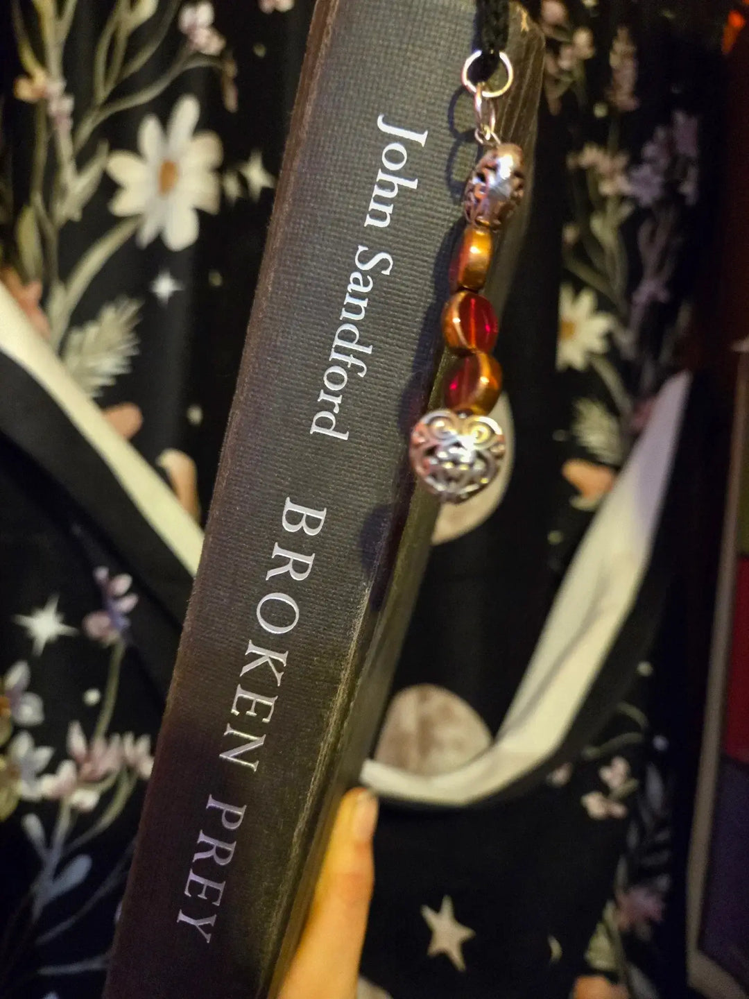 Bookmark attached to the book 'Broken Prey' by John Sandford, showcasing a decorative design.