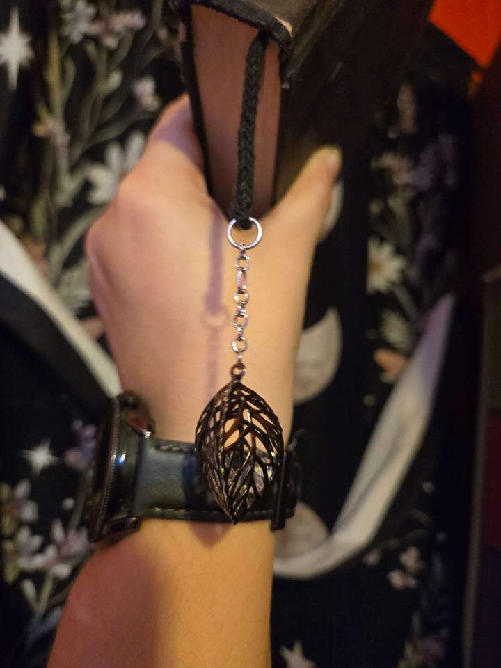 Artistic bookmark hanging from a book, showcasing its unique design and style as a useful accessory.